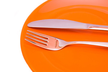 Plate with cutlery on a white background seen up close