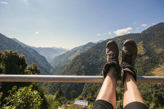 Legs of traveler sitting on Himalaya high Mountains in travel. Freedom concept