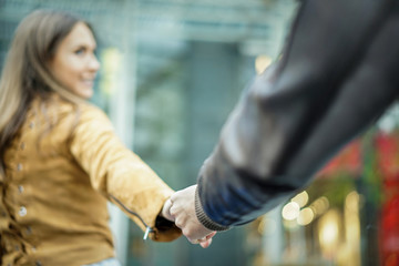 Young man following young woman in city urban center