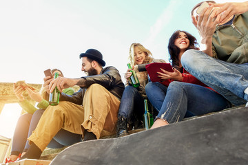 Group of happy friends toasting beers and eating pizza take away