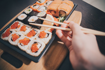Set sushi set. Hand with chopsticks for sushi.
