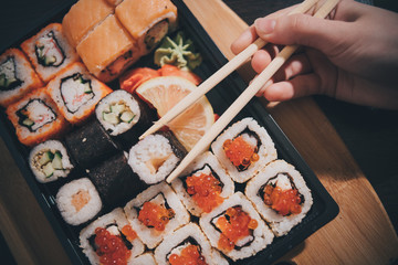 Set sushi set. Hand with chopsticks for sushi.
