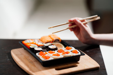 Set sushi set. Hand with chopsticks for sushi.
