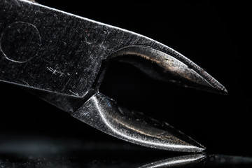 Old forceps close isolated against a black background