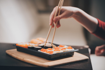 Set sushi set. Hand with chopsticks for sushi.

