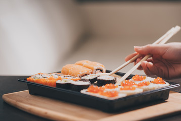Set sushi set. Hand with chopsticks for sushi.
