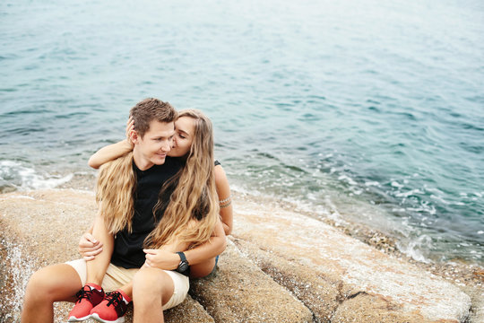 Happy couple in love on beach summer vacations. Joyful girl piggybacking on young boyfriend kiss and enjoy together in tropical beach for travel holiday