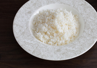 White Rice in the dish on dark brown wooden plate