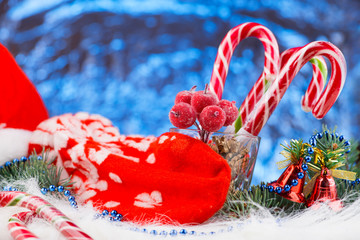 hand Santa Claus with Christmas candy closeup on blur background