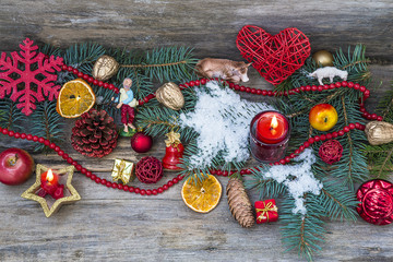 Christmas composition with biblical figures, burning candles, christmas decorations, snow on old wooden background