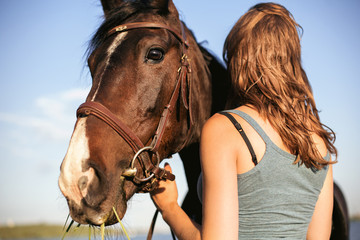 Obraz premium Portrait of Brown hors with brown hair woman outdoor