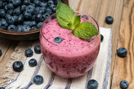 Blueberry smoothie  and berries  on wooden table