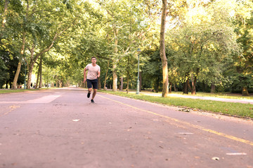 A handsome young man jogging in a park