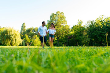 Beautiful young couple walking together in the park	