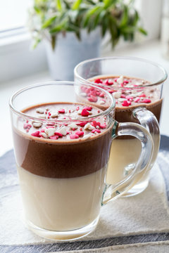 Delicious vanilla and chocolate pannacotta with sugar hearts in a glass