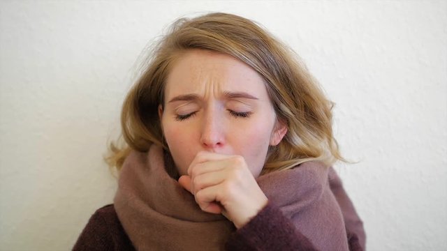Junge europ&auml;ische Frau ist erk&auml;ltet und hustet in Zeitlupe