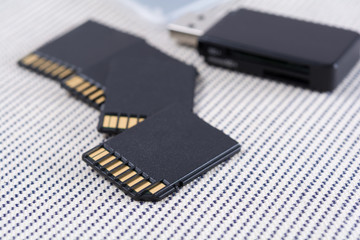 Black memory cards and card reader on textile background