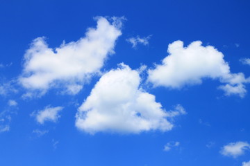 Spring sky with white clouds , cloud in the middle has the shape of the heart