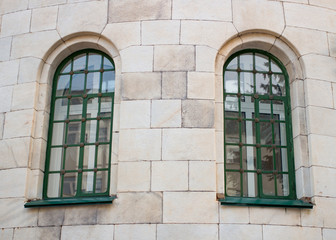 Two historic green window on the yellow wall