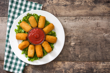 Traditional fried Spanish croquetas (croquettes) with ketchup in plate on wooden background
