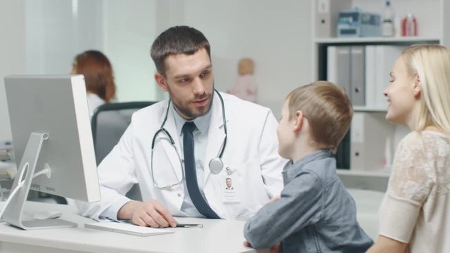 At Doctor's Office. Well Natured Male Doctor Talks and Jokes with Little Boy and His Mother. Shot on RED Cinema Camera in 4K (UHD).