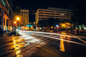 Fototapeta premium Tram tracks and buildings at night, in downtown Norfolk, Virgini