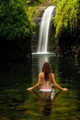 Young woman in bikini standing at Wainibau Waterfall on Taveuni
