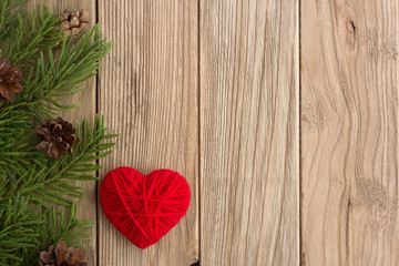 branch of Christmas tree and wool heart on wooden table