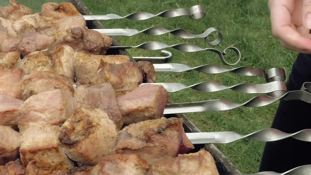 Barbeque skewers with meat cooking on hot coal ember brazier Outdoors picnic concept.