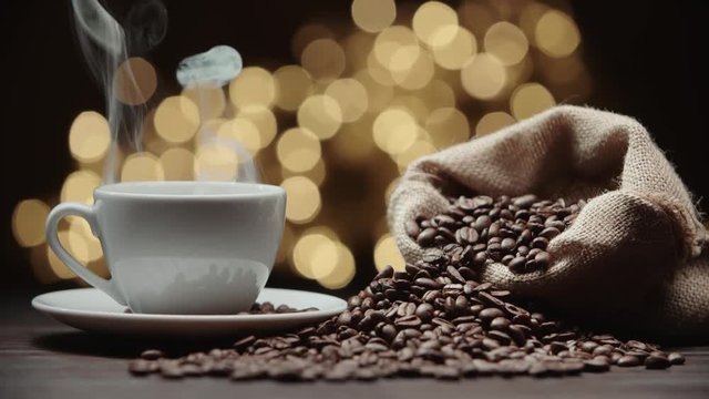 beautiful composition the Cup of hot coffee and coffee beans on the table, magic bokeh background