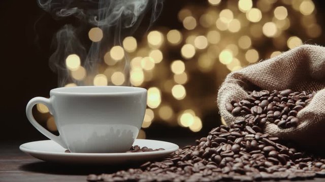 beautiful composition the Cup of hot coffee and coffee beans on the table, magic bokeh background