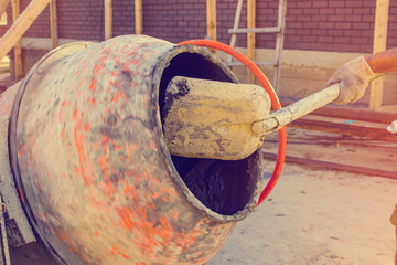 Builder fills the cement mixer, on the construction site