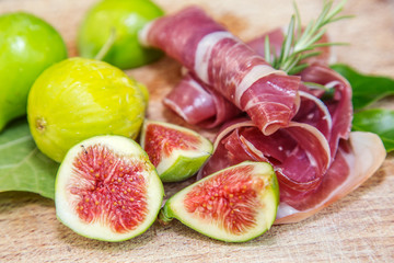 Ripe fig fruits and bacon or prosciutto. Food to accompany the d