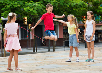Kids in school age playing together with jumping rope