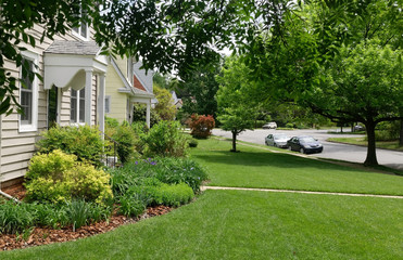 Fototapeta na wymiar Residential city block in spring. Homes, sidewalk, green lawn.