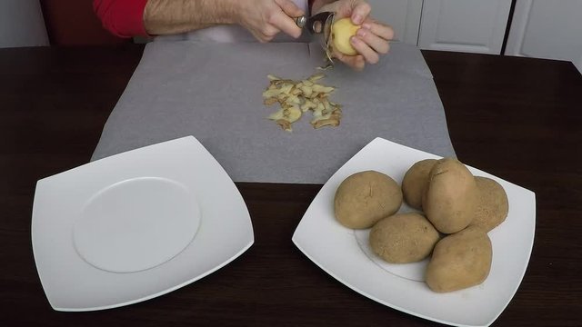 Time lapse of Man peling potatoes on table
