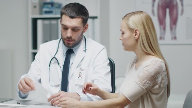 Male Doctor Writes a Prescription to His Young Female Patient and Gives it to Her.  Shot on RED Cinema Camera in 4K (UHD).
