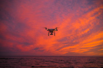 Fototapeta na wymiar Flying drone on the sunset beach