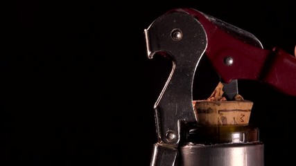 Opening a wine bottle with corkscrew, black background, Winery