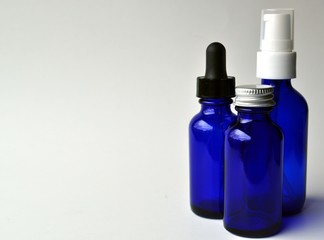 Group of dark blue glass bottles for cosmetic lotions, serums, oils and liquids