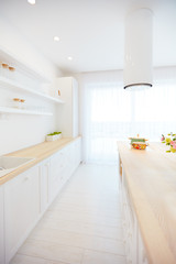 white wooden kitchen with island cooker hood and hanging shelves