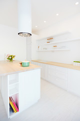 white wooden kitchen with island cooker hood and hanging shelves