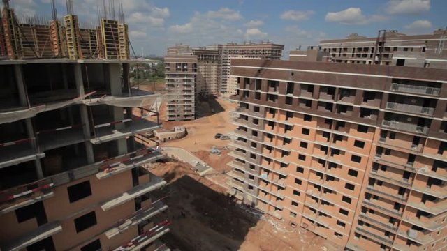  Development of infrastructure. Aerial views of a large construction site. The camera moves past unfinished buildings