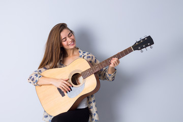 Fototapeta premium Young woman holding a guitar 