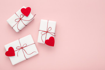 Valentine day composition: white gift boxes with bow and red felt hearts, photo template,...
