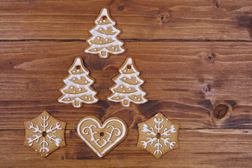 Christmas tree decoration made from gingerbread cookies on wooden table. New year background, copy space