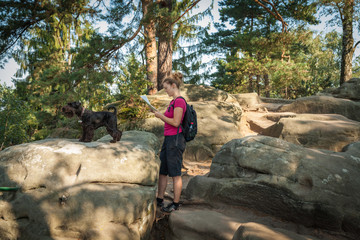 Young woman and her dog enjoy mountain hikes in summer