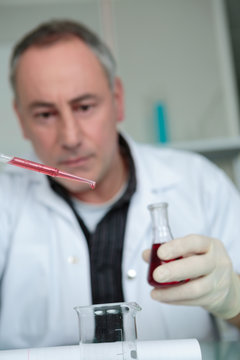 man in laboratory with pipette in the clinic research