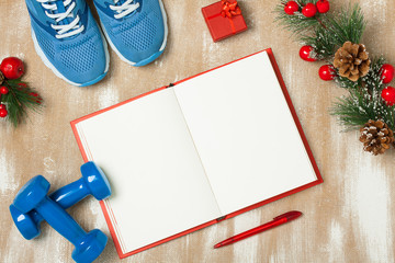 Christmas sport composition with  shoes, dumbbells and note