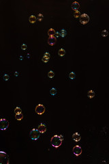 Colorful soap bubbles over black background